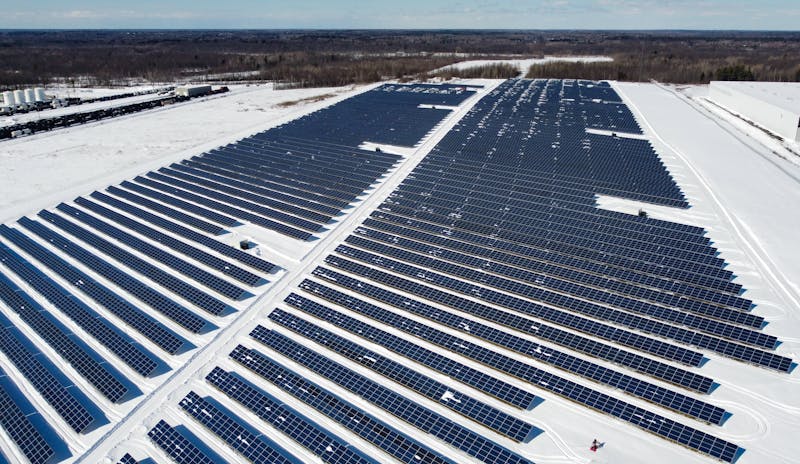 A drone-captured image of a large solar farm in Kingston, Canada, surrounded by snow.